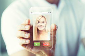 business, technology and people concept - close up of male hand holding and showing transparent smartphone with incoming call on screen