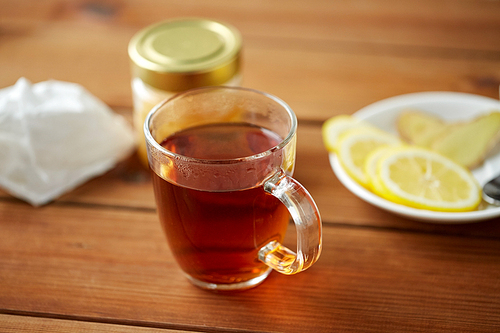 health, traditional medicine, folk remedy and ethnoscience concept - tea cup with lemon and honey