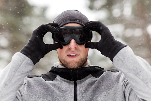 fitness, winter sport, people and healthy lifestyle concept - young man in ski goggles outdoors