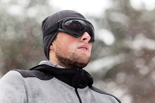 fitness, winter sport, people and healthy lifestyle concept - young man in ski goggles outdoors