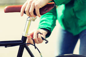 people, vehicle, eisure and lifestyle - close up of man adjusting fixed gear bike saddle high
