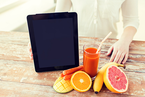 healthy eating, technology, diet and people concept - close up of woman hands with tablet pc, fruits and fresh juice sitting at table