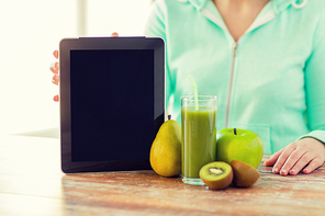 healthy eating, technology, diet and people concept - close up of woman hands with tablet pc, fruits and fresh juice sitting at table