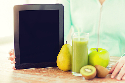 healthy eating, technology,  and people concept - close up of woman hands with tablet pc, fruits and fresh juice sitting at table