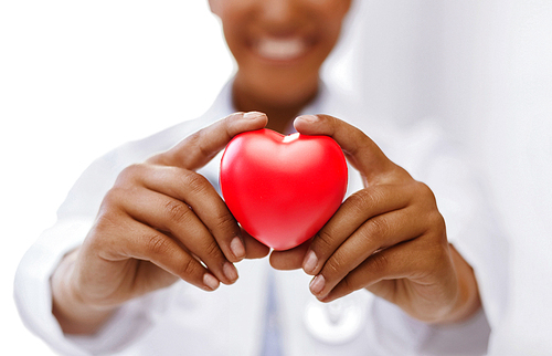 health, medicine and charity concept - close up of african american female doctor hands holding red heart