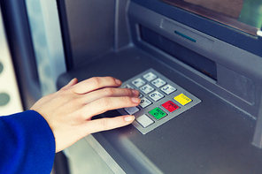 finance, technology, money and people concept - close up of hand entering pin code at cash machine