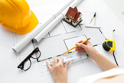 business, architecture, building, construction and people concept - close up of architect hands with ruler and pencil measuring living house blueprint