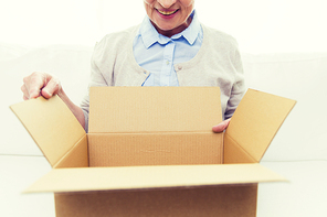 age, delivery, mail, shipping and people concept - close up of happy smiling senior woman looking into open parcel box at home