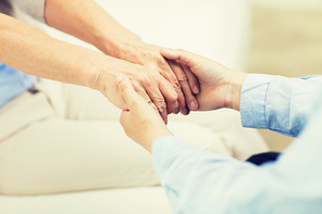 people, age, family, care and support concept - close up of senior and young woman  holding hands