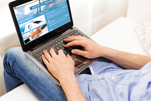 technology, people, mass media and lifestyle concept - close up of male hands typing on laptop computer with business news web site on screen at home