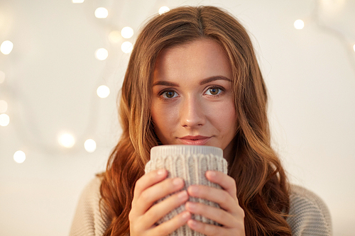 drink, christmas, winter, holidays and people concept - happy young woman with cup of coffee or tea at home