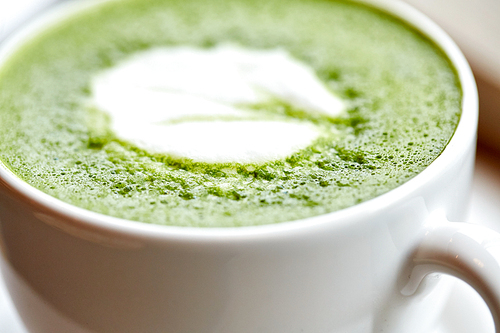 drink, , weight-loss and slimming concept - close up of white cup of matcha green tea latte on table at restaurant or cafe