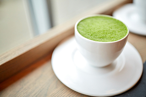drink, , weight-loss and slimming concept - white cup of matcha green tea latte on table at restaurant or cafe