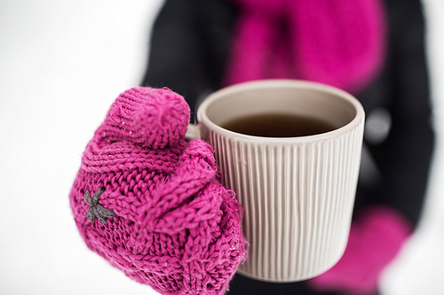 people, season, drinks and leisure concept - close up of woman with tea mug outdoors in winter