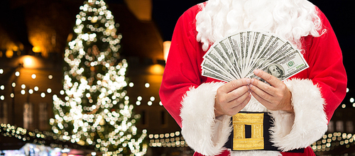 holidays, finances and people concept - close up of santa claus with dollar money over christmas tree background