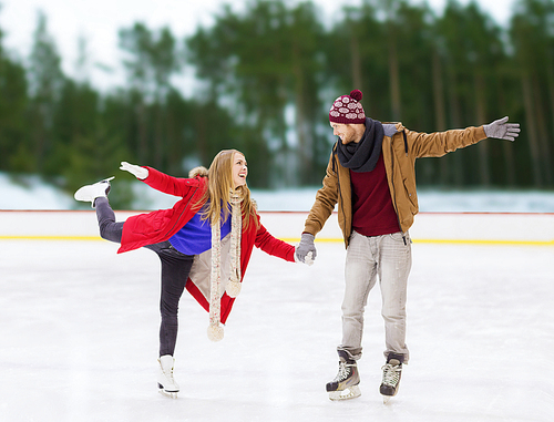 winter and leisure concept - happy couple holding hands on skating rink