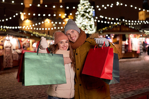 holidays, christmas and people concept - happy couple at with shopping bags in winter