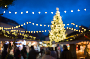 holidays, sale and retail concept - evening christmas market at old town hall square in tallinn bokeh