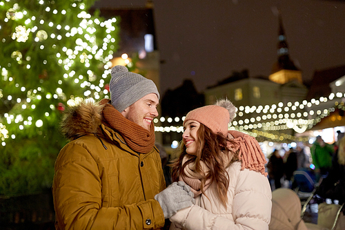 winter holidays and people concept - happy young couple dating at christmas market in evening