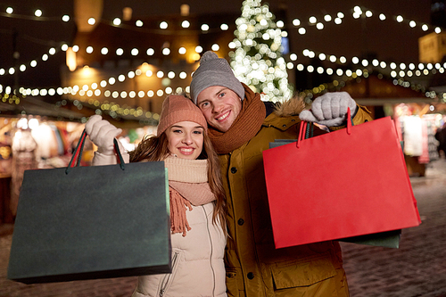 holidays, christmas and people concept - happy couple at with shopping bags in winter