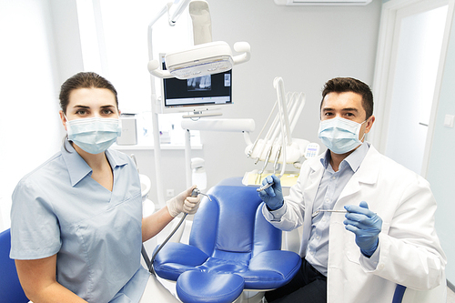people, medicine, stomatology and health care concept - close up of dentist and assistant with dental mirror, drill and air water gun spray at dental clinic