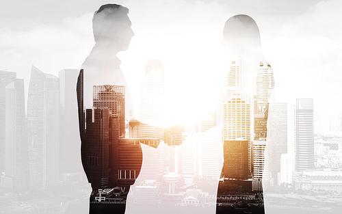 business, partnership and cooperation concept - businessman and businesswoman silhouettes shaking hands over city background