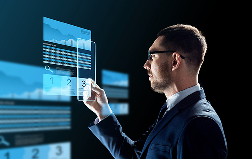 business, augmented reality and future technology concept - businessman in glasses working with transparent tablet pc computer and virtual exchange charts projections over black background