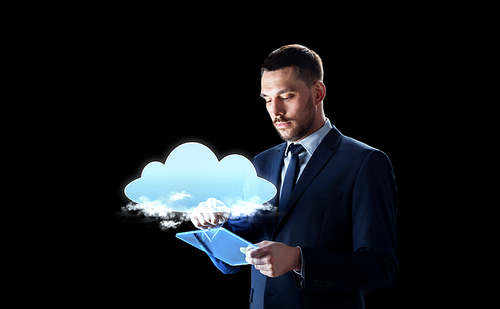 business, people and future technology concept - businessman in suit working with transparent tablet pc computer and virtual cloud hologram over black background