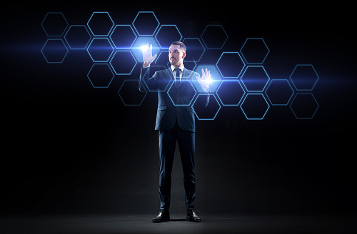 business, people, augmented reality and future technology concept - businessman working with virtual network hologram over black background