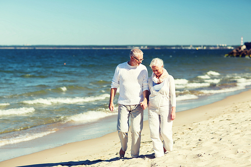 family, age, travel, tourism and people concept - happy senior couple holding hands and walking on summer beach