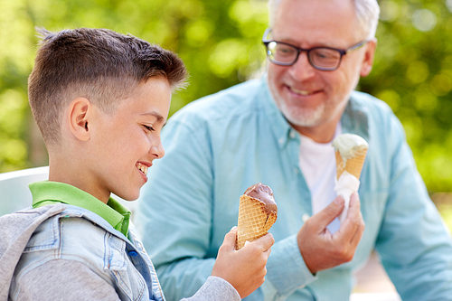 family, generation, communication and people concept - happy grandfather and grandson eating ice cream at summer park