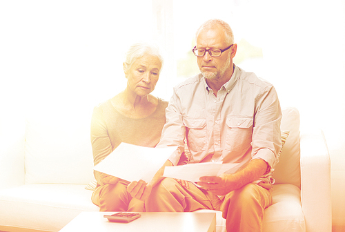 family, business, savings, age and people concept - smiling senior couple with papers and calculator at home