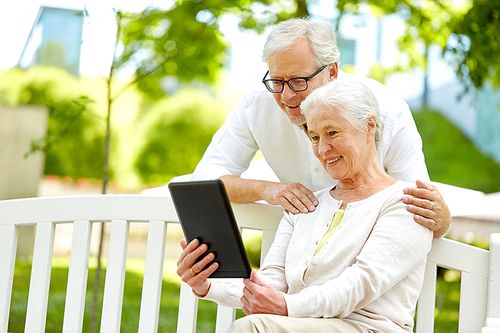 retirement, technology and old people concept - happy senior couple with tablet pc computer at summer park