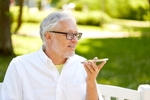 technology, senior people and communication concept - old man using voice command recorder or calling on smartphone at summer park