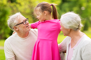 family, generation and people concept - happy smiling grandmother, grandfather and little granddaughter at park