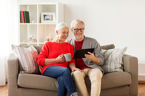 christmas, holidays and people concept - happy senior couple with tablet pc computer at home