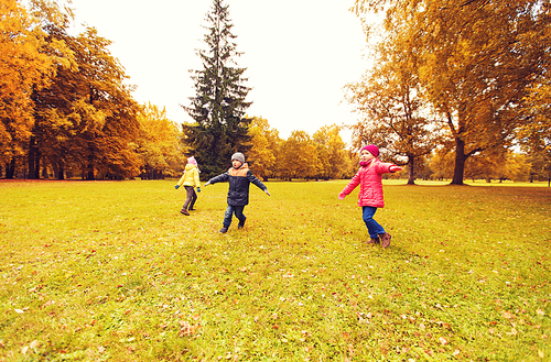 autumn, childhood, leisure and people concept - group of happy little children running and playing planes outdoors