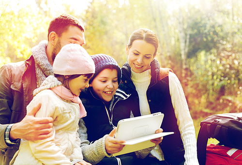 travel, tourism and hike concept - happy family with tablet pc computer and backpacks at camp in woods