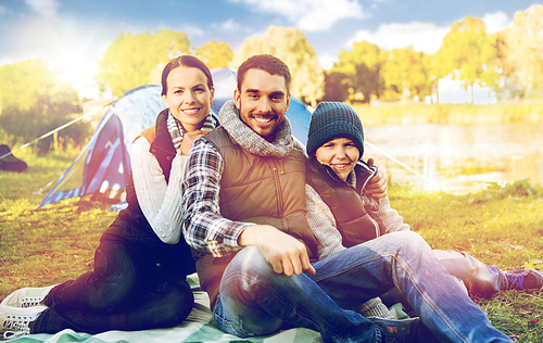 tourism, hike and travel concept - happy family over tent at camp site