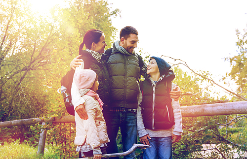 travel, tourism, hike and people concept - happy family with backpacks hiking in woods