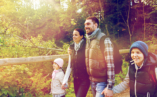 travel, tourism and hike people concept - happy family walking with backpacks outdoors