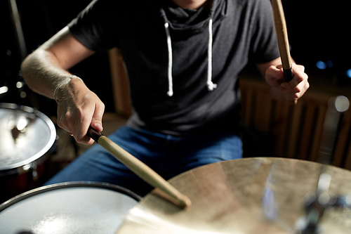 music, people, musical instruments and entertainment concept - male musician playing drums and cymbals at concert or studio