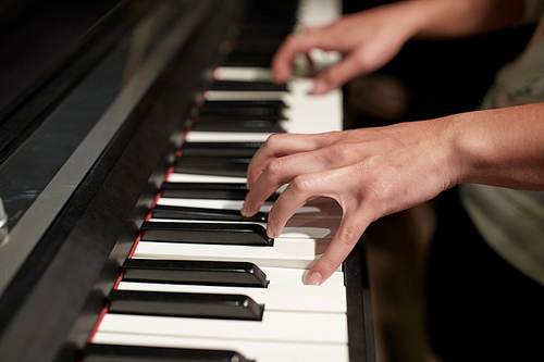 music, people, art, musical instruments and entertainment concept - close up of hands playing piano
