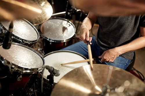 music, people, musical instruments and entertainment concept - male musician playing drums and cymbals at concert or studio