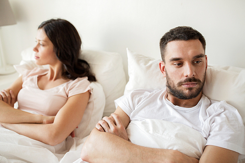 people, relationship difficulties and family concept - unhappy couple having conflict in bed at home
