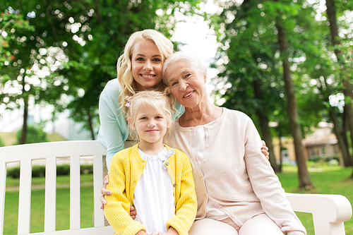 family, generation and people concept - happy smiling woman with daughter and senior mother sitting on park bench