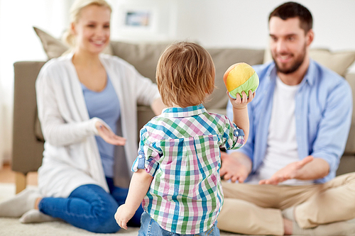 family and people concept - happy little son and parents playing with ball at home