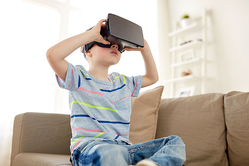 technology, augmented reality, entertainment and people concept - little boy with virtual headset or 3d glasses playing at home