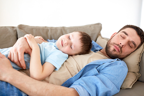 family, childhood, fatherhood, leisure and people concept - portrait of happy father and little son sleeping on sofa at home
