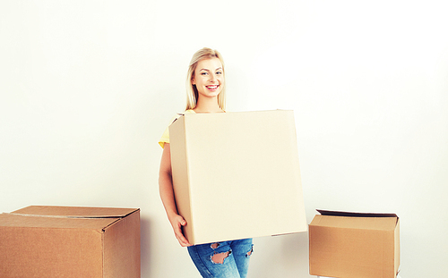 moving, delivery, housing, accommodation and people concept - smiling young woman with cardboard box at home